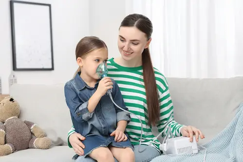 Child receiving respiratory therapy at home with a caregiver—representing pediatric home care services.
